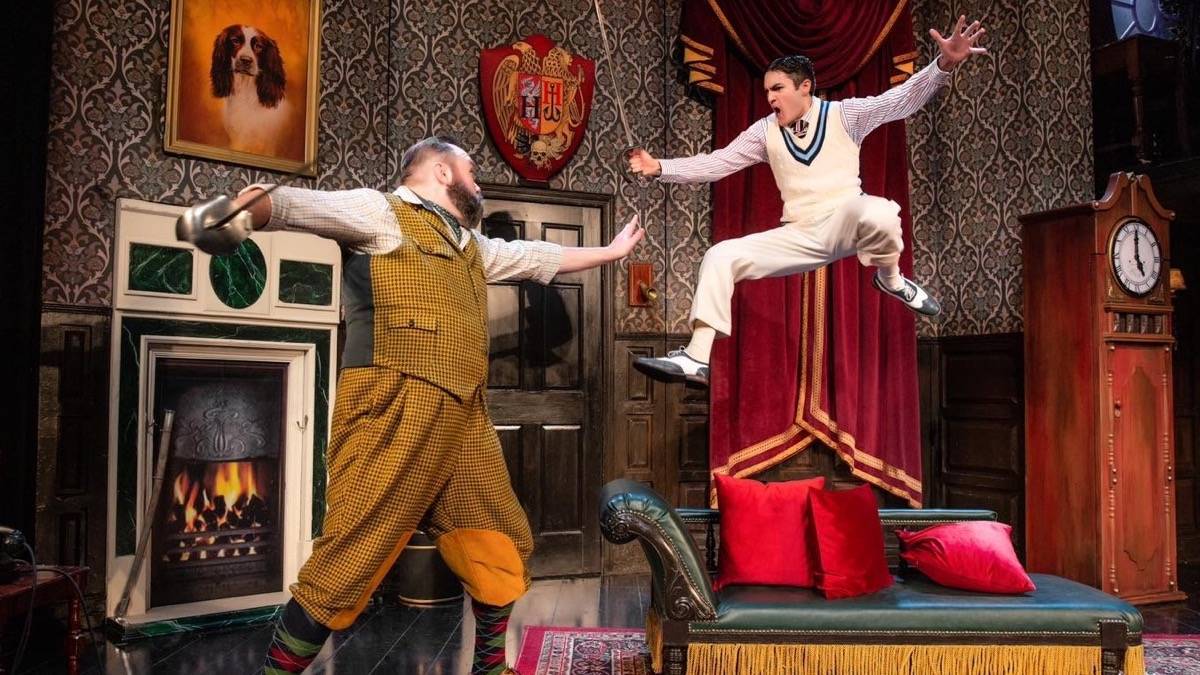 Two cast members fencing and jumping around on stage